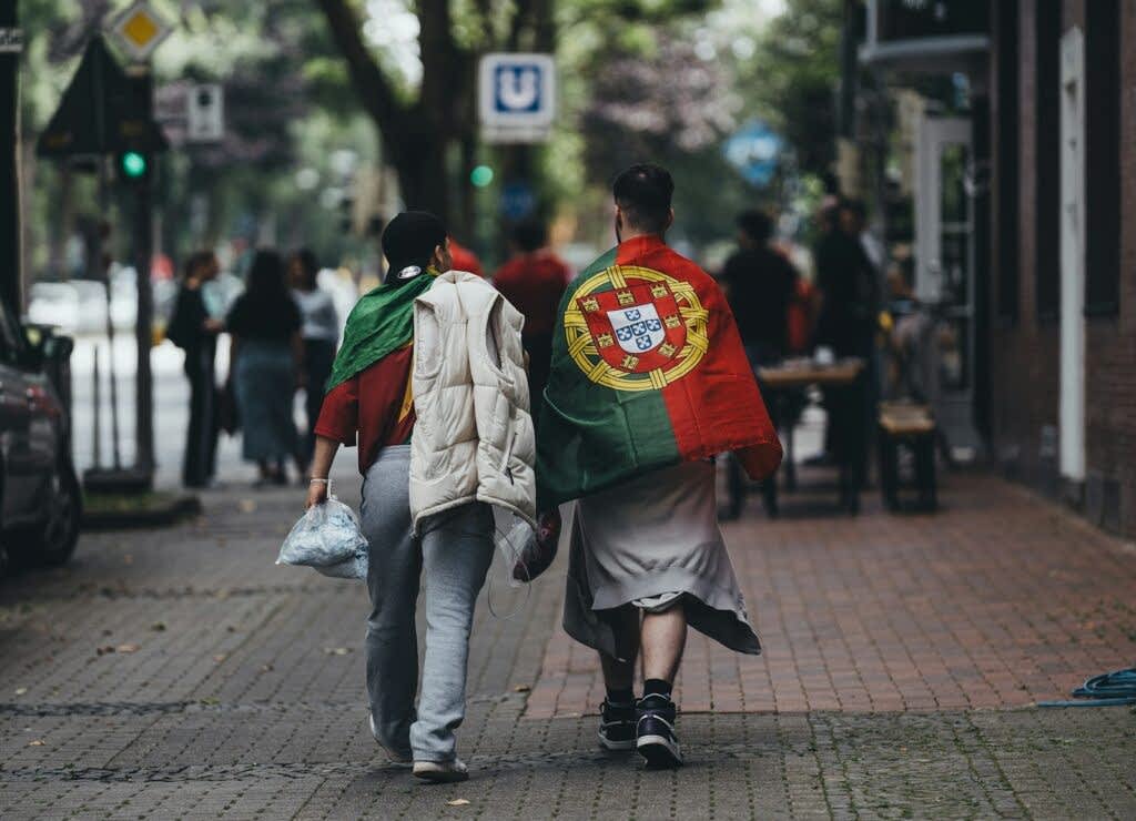 A couple of people walking down a street