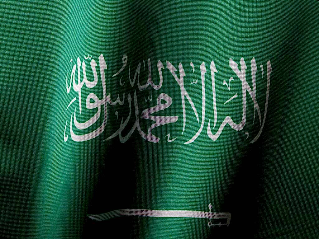 Detailed close-up of the Saudi Arabian flag showcasing the elegant Arabic script and vibrant green color.