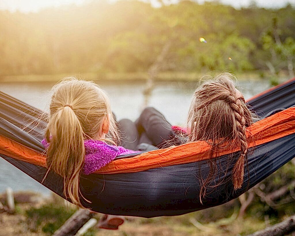 two women lying on hammock