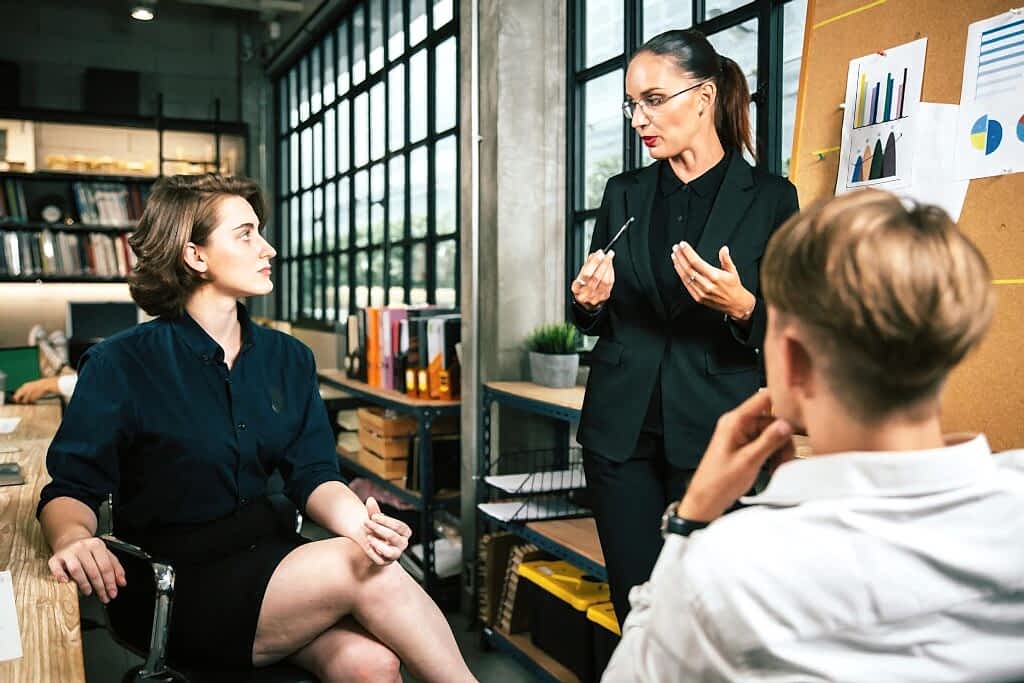 Three colleagues engage in a vibrant business meeting in a modern office setting.