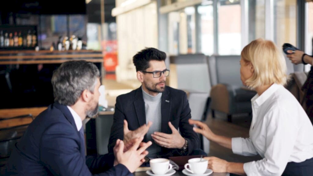 Colleagues having a strategic discussion over coffee in a stylish café.