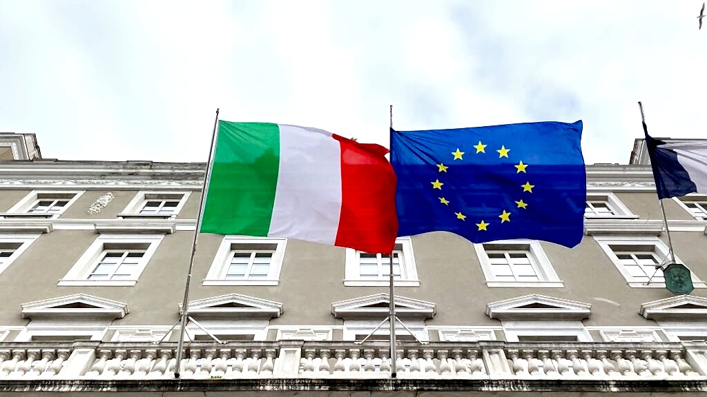 two flags are flying in front of a building