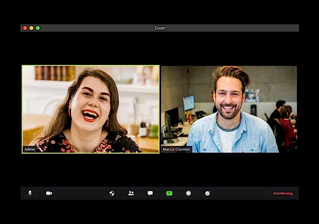 man in blue dress shirt smiling beside woman in black and red floral dress